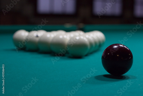 Russian billiard:  black and white balls on green table