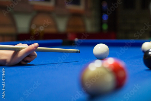 Eight-ball pool player aims to shoot balls with cue photo