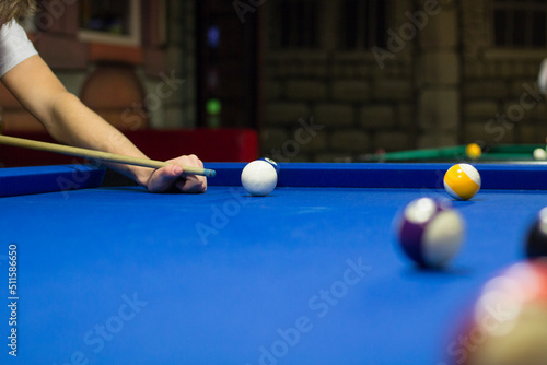Pool player aims to shoot balls with cue photo