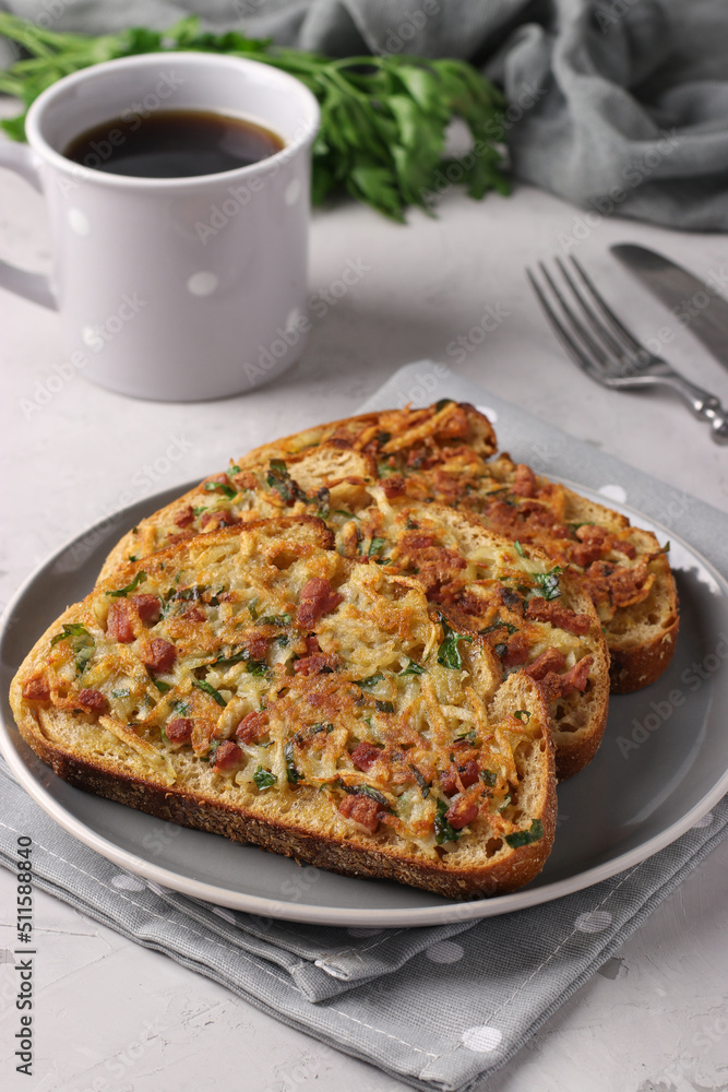 Hot sandwiches with potatoes and sausage in a plate and cup of coffee on gray table Hot sandwiches with potatoes and sausage in a plate and cup of coffee on gray table