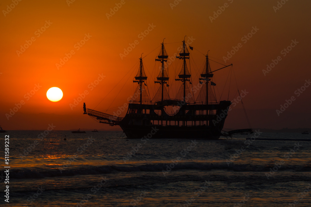 Pirate ship in the mediterranean sea. Evening landscape with a ship at sunset