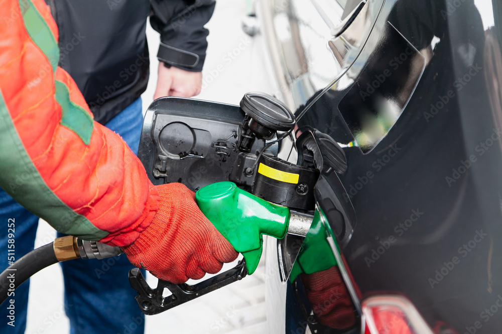 process of refueling car by employee in red jacket.... process of refueling car by employee in red jacket....