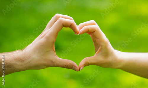 Hands, heart, couple. Closeup of couple making heart shape with hands. The hands of women and men are the heart the hands. Beautiful young couple is making heart of fingers © Yevhen
