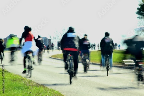 Cyclists riding small hill in urban setting with motion blur