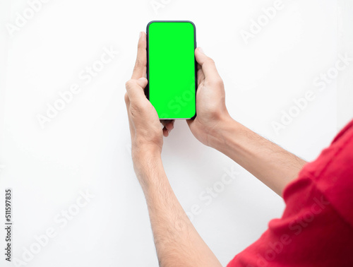 Mano de un hombre joven con su telefono inteligente tomando una foto con fondo verde en aislado blanco 