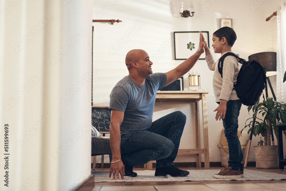 Raise them good, praise them good. Shot of an adorable little boy giving his father a high five before leaving to go to school. Raise them good, praise them good. Shot of an adorable little boy giving his father a high five before leaving to go to school.