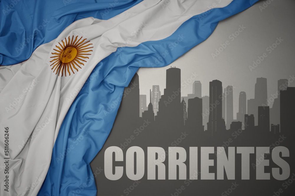 abstract silhouette of the city with text Corrientes near waving national flag of argentina on a gray background.