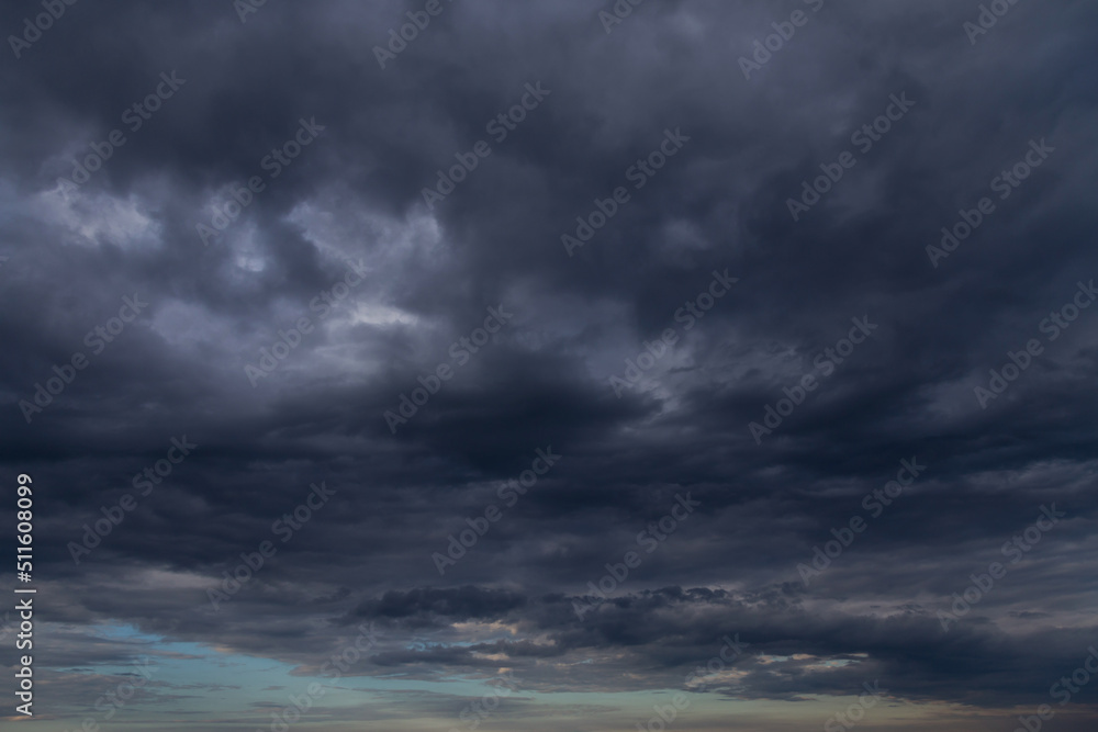 Storm sky with dark grey cumulus clouds and blue sky background texture, thunderstorm