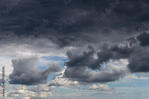Epic Storm sky, dark grey and white rain cumulus clouds on blue sky background texture