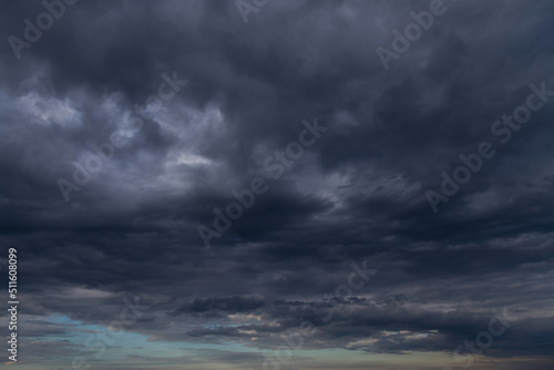 Storm sky with dark grey cumulus clouds and blue sky background texture, thunderstorm