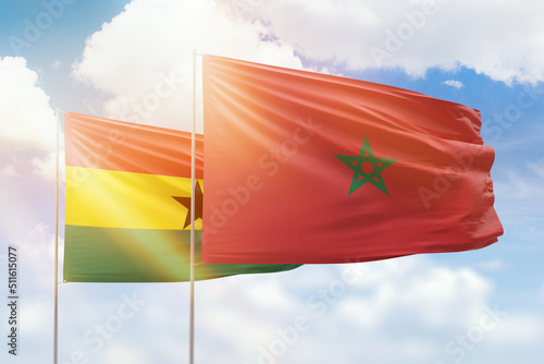 Sunny blue sky and flags of morocco and ghana