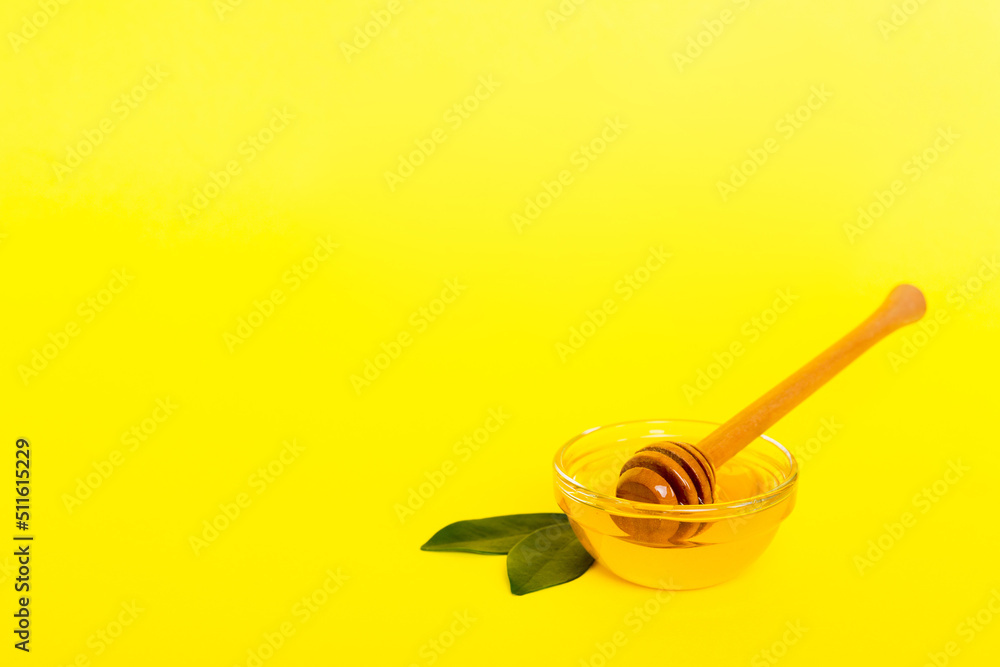 Fototapeta premium Honey in jar with leaves and honey dipper on colored background top view with copy text