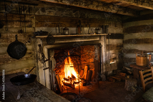 Old house interior with utensils and burning fireplace. © Karlsson Photo