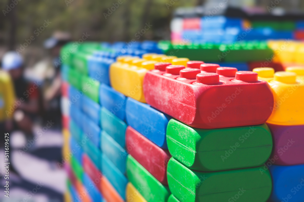 Children play colorful big toy blocks in kindergarten day care center playground, kids playing with various plastic mega construction blocks bricks