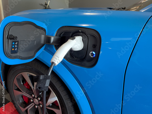 Blue Electric Car Plugged in and Charging