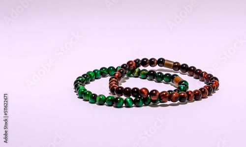 Two beautiful bracelets of green and brown on a purple background. 