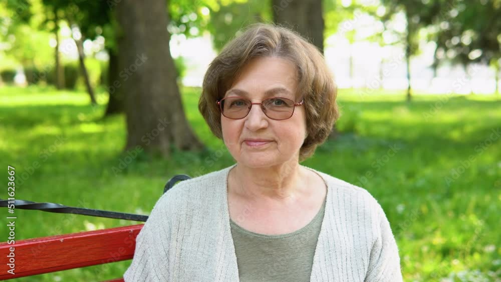 Portrait of an old caucasian woman smiling happily looking at the camera in park. Active retirement lifestyle and spending time outdoors Portrait of an old caucasian woman smiling happily looking at the camera in park. Active retirement lifestyle and spending time outdoors