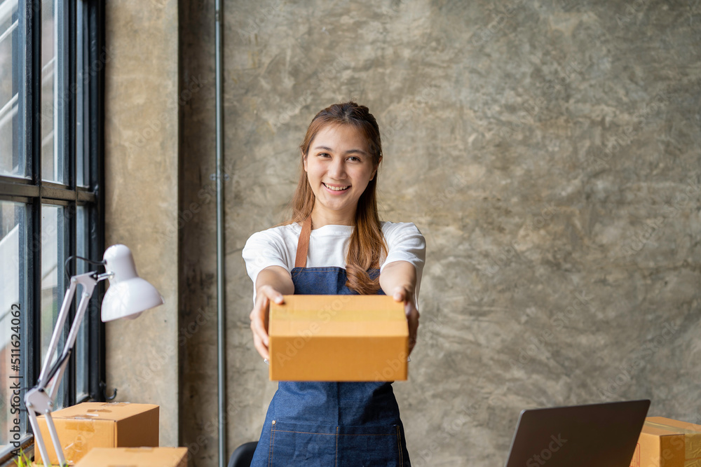 Portrait of Asian young woman SME working with a box at home the workplace.start-up small business owner, small business entrepreneur SME or freelance business online and delivery concept. Portrait of Asian young woman SME working with a box at home the workplace.start-up small business owner, small business entrepreneur SME or freelance business online and delivery concept.