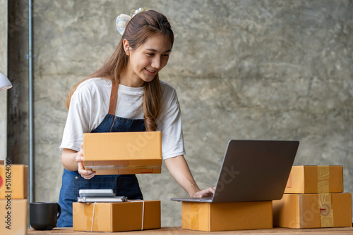 Portrait of Starting small businesses SME owners female entrepreneurs working on receipt box and check online orders to prepare to pack the boxes, sell to customers, sme business ideas online.