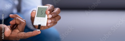 Man Checking Blood Sugar Level With Glucometer