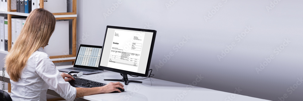 Businesswoman Checking Invoice On Computer Businesswoman Checking Invoice On Computer
