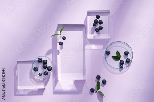 Fotografija Top view of blueberry extract with transparent podium and blank space in purple
