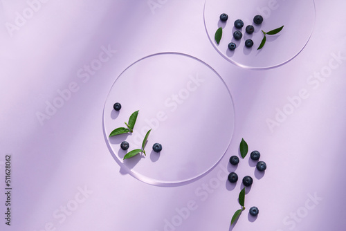 Top view of blueberry extract with transparent podium and blank space in purple background  photo