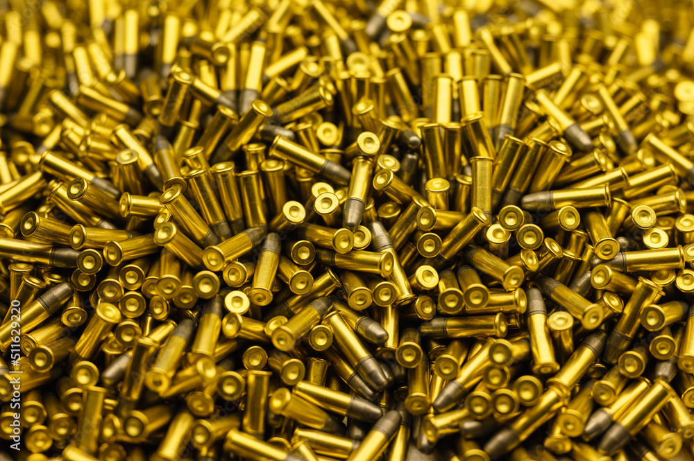 Heap of black and golden small-caliber bullets on table Heap of black and golden small-caliber bullets on table