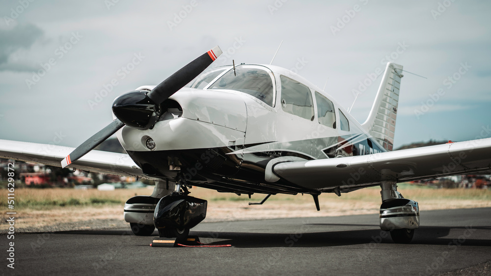 White small propeller airplane parked at ramp White small propeller airplane parked at ramp
