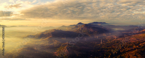 Aerial view panorama Morning scenic on high mountains with electricity pylon Pang Puay, Mae Moh, Lampang, Thailand. Beautiful morning with golden sunrise and fog flowing. photo