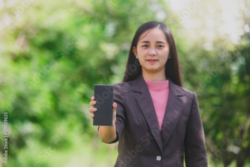 business woman Standing on the phone in the park beside the town © Tanarat