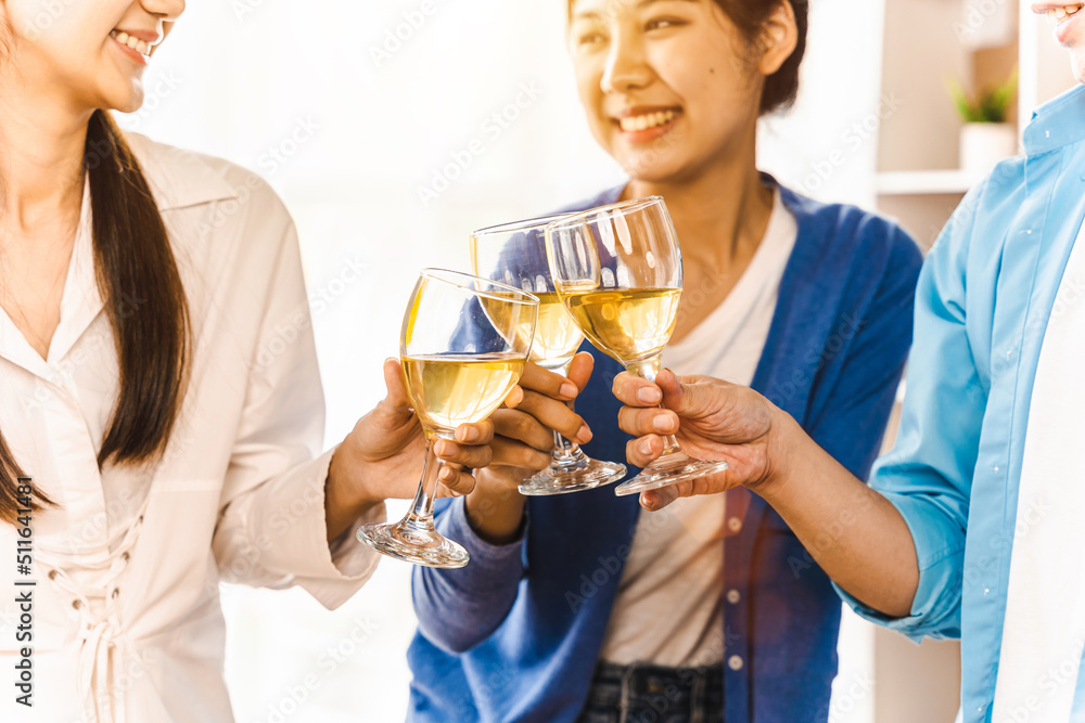 Happy Asian people eating pizza and cheering with white wine at coworking office during break. Food delivery and team work concept Happy Asian people eating pizza and cheering with white wine at coworking office during break. Food delivery and team work concept