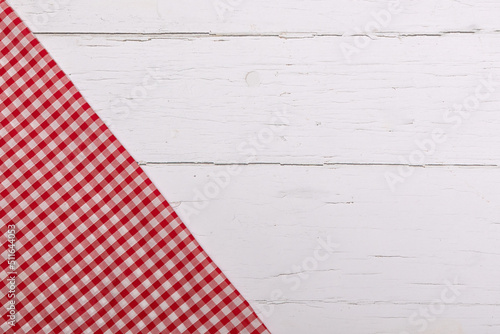 Red gingham table cloth on corner of white wooden table. Flat lay with copy space 