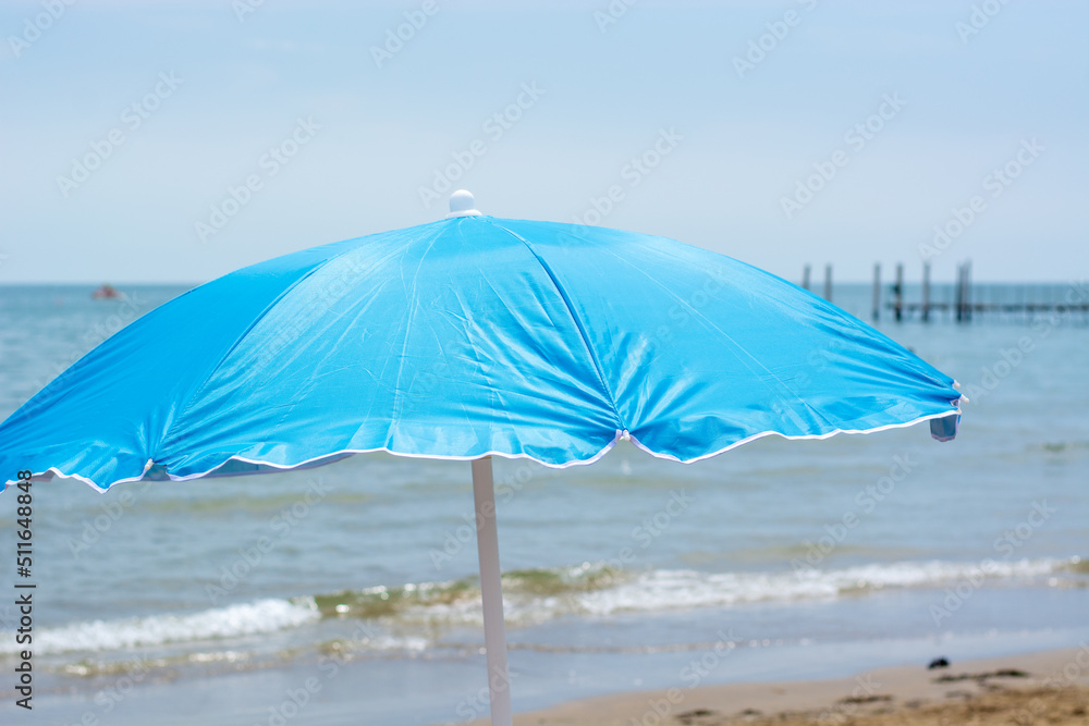 a blue beach umbrella in front of the sea