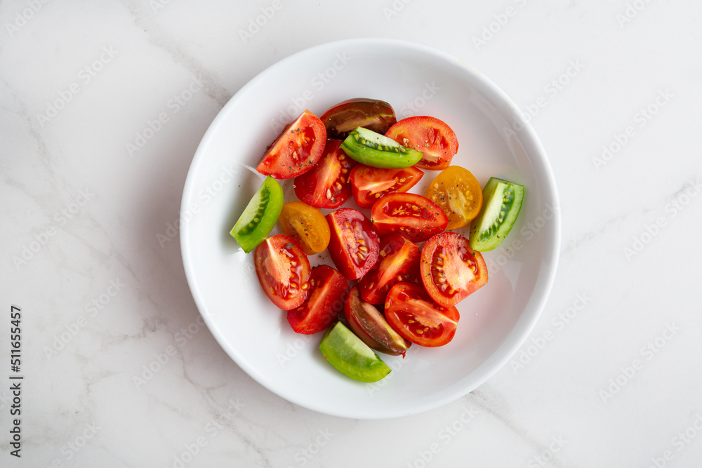 Overhead view of sliced tomatoes for salad in white bowl Overhead view of sliced tomatoes for salad in white bowl