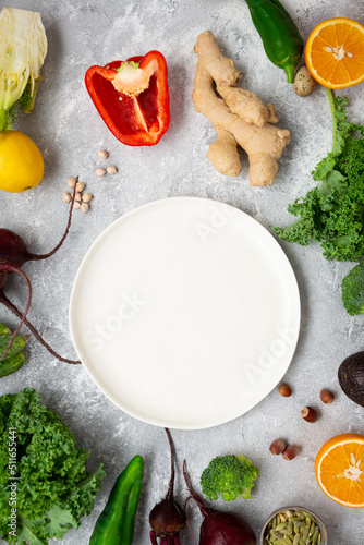 White plate empty and dfferent vegetables around cooking food concept photo