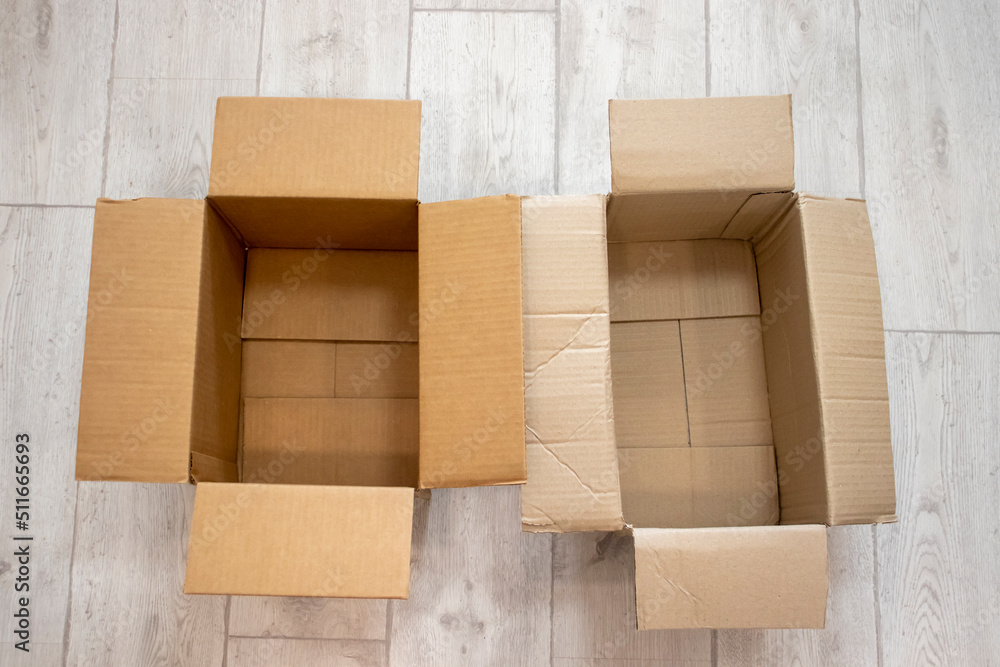 Empty open cardboard boxes against a background of white wood laminate Empty open cardboard boxes against a background of white wood laminate
