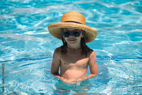 Kid boy swim in swimming pool. Summertime and swimming activities for children on the pool. Active kids healthy lifestyle, water sport activity and swimming lessons on summer vacation with child.