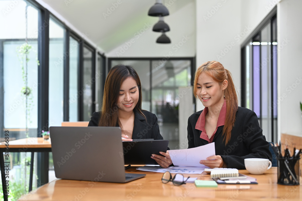 Young business people discussing project statistics or financial report together at office desk Young business people discussing project statistics or financial report together at office desk