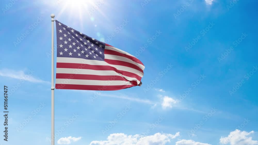 The national flag of the United States of America with stripes of red and white color and stars flutters in the wind against a blue sunny sky and glare. freedom and independence concept The national flag of the United States of America with stripes of red and white color and stars flutters in the wind against a blue sunny sky and glare. freedom and independence concept