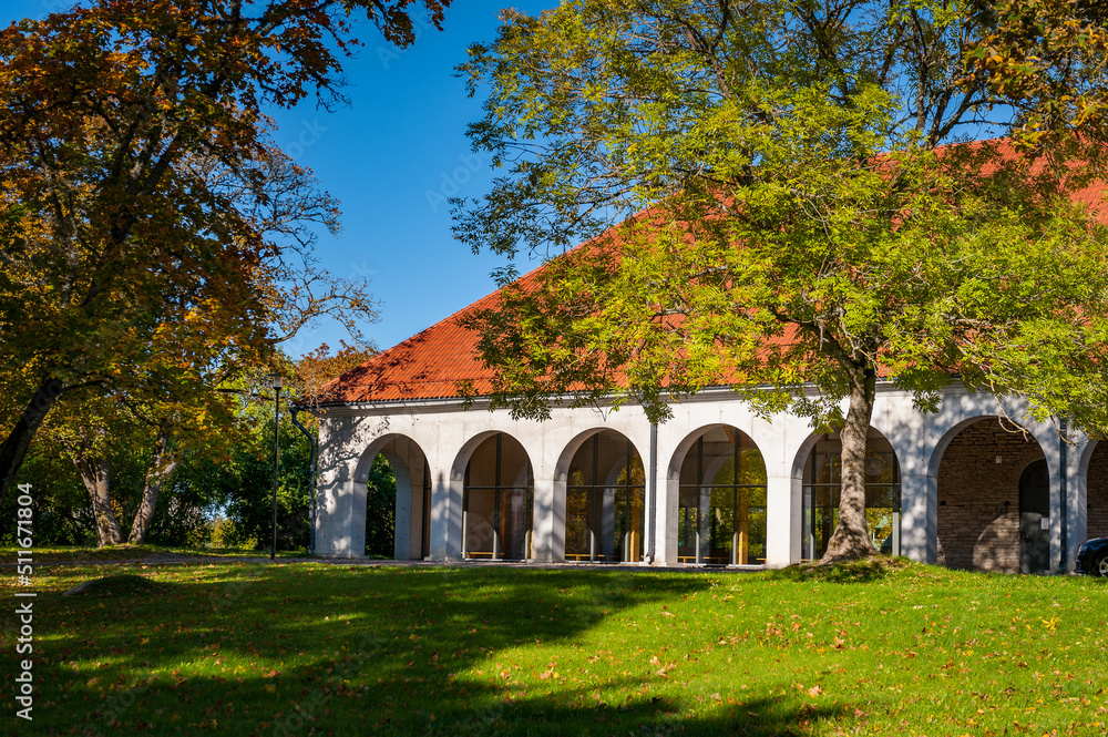 View of the outside of a renovated stable block of Vääna Manor. Old stables now houses a school. Sunny autumn weather drew tourists to enjoy the beautiful Manor, Estonia. Built in the 18th centur. View of the outside of a renovated stable block of Vääna Manor. Old stables now houses a school. Sunny autumn weather drew tourists to enjoy the beautiful Manor, Estonia. Built in the 18th centur.