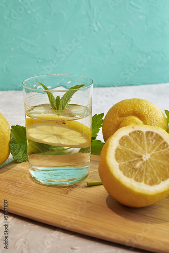 a glass of water with lemons and mint on the table