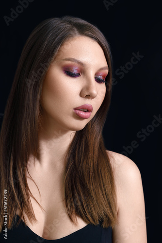 vertical beauty portrait of a brunette woman on a black background.