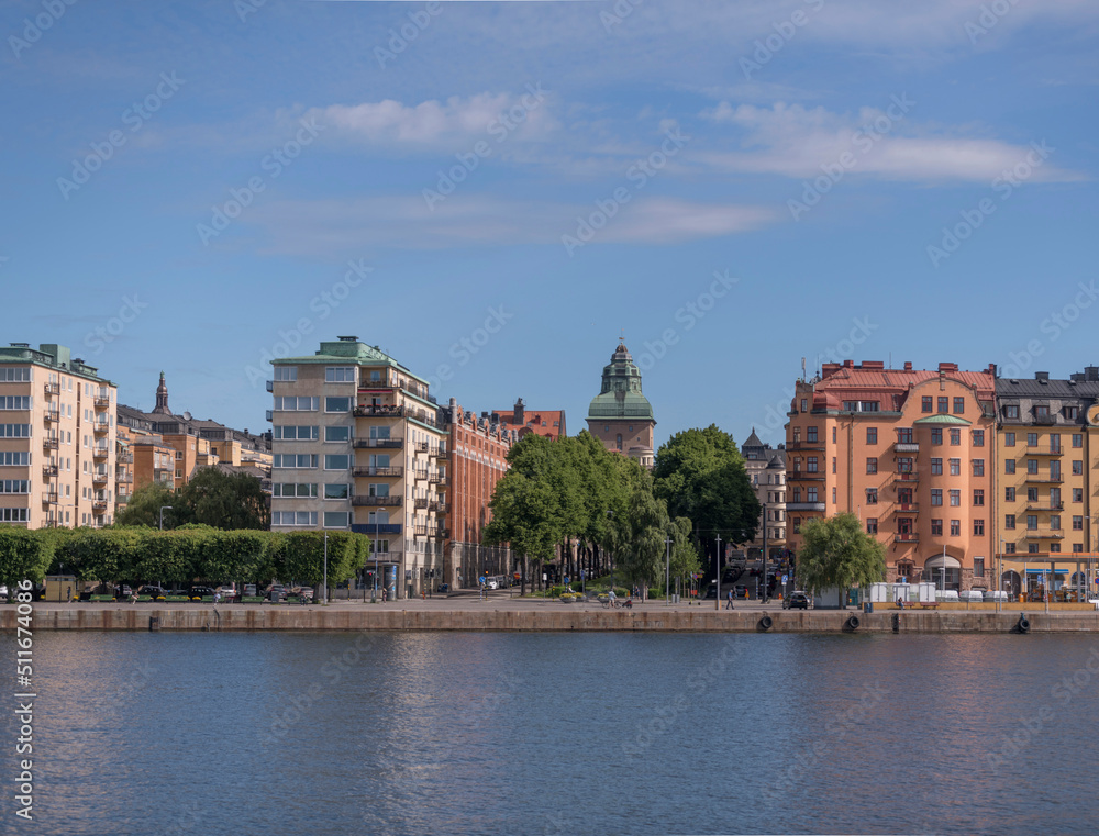 Apartment houses at the waterfront and the tower of a court house on the island Kungsholmen a sunny summer day in Stockholm