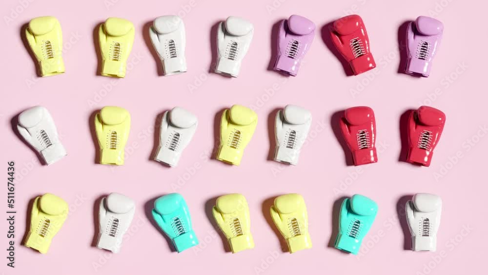 Closeup Stop motion Colorful Random Boxing glove put on Pink color background. 3D animation 4K. Stop motion Sport concept. Closeup Stop motion Colorful Random Boxing glove put on Pink color background. 3D animation 4K. Stop motion Sport concept.