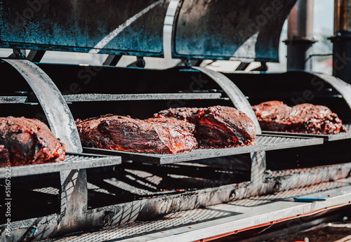 Fotografija slow cooked beef brisket meat on the grill grates of a smoker barbecue