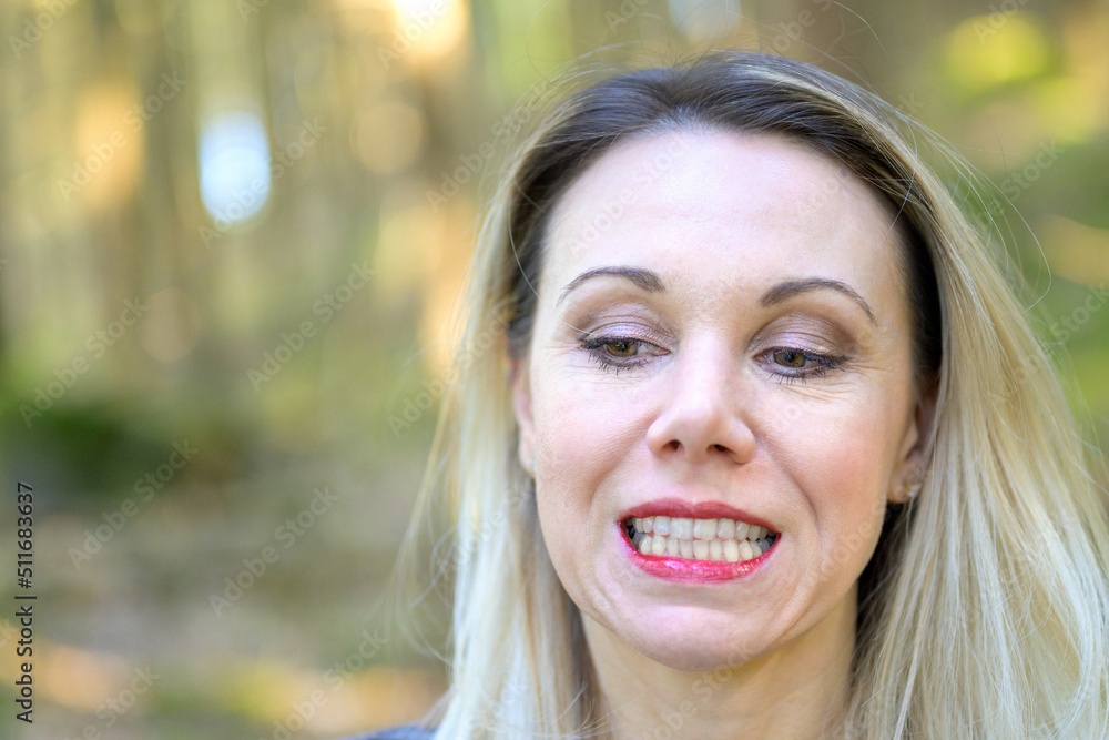 Blond woman wearing makeup baring her teeth to the camera Blond woman wearing makeup baring her teeth to the camera