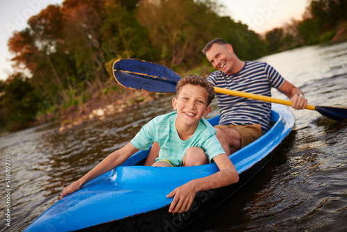 Hes an adventurous little guy. Shot of a father and son rowing a boat together on a lake.