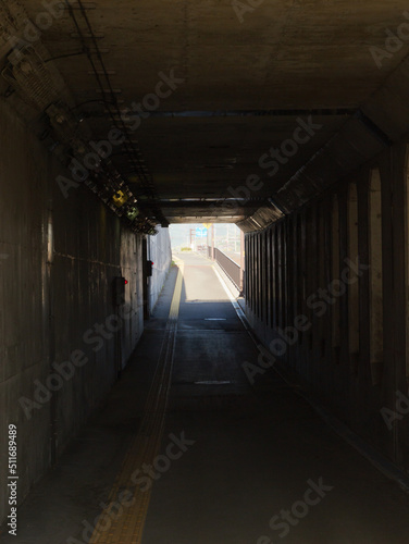 In the pitch-dark, long, eerie tunnel, see a bright exit on the other side.