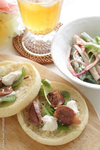 Canned food, smoked chicken gizzard and cream cheese in English muffin sandwich with salad and drink